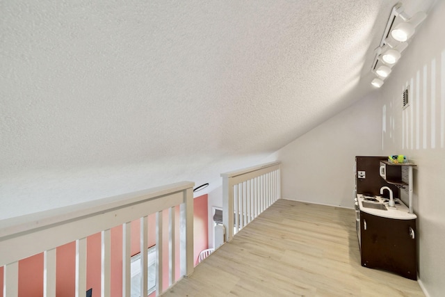 736 Sandpiper Pl Unit 10525, Miramar Beach, FL 32550 - hallway featuring a textured ceiling, light wood-style floors, and track lighting