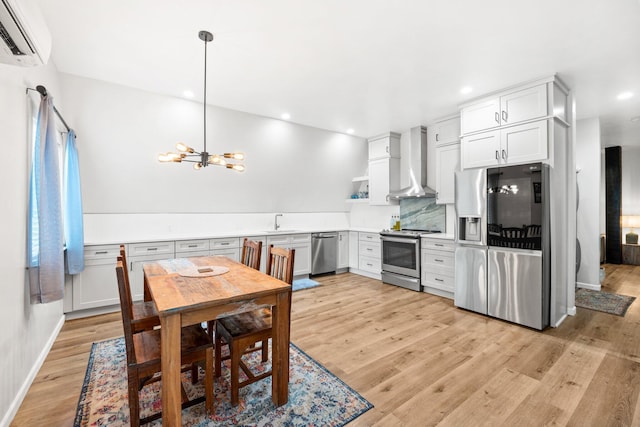 250 Bayou Cir, Freeport, FL 32439 - kitchen featuring appliances with stainless steel finishes, wall chimney exhaust hood, a wall unit AC, open shelves, and light wood-type flooring