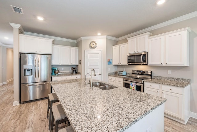 364 Lightning Bug Ln, Freeport, FL 32439 - kitchen featuring stainless steel appliances, an island with sink, white cabinets, a breakfast bar, and crown molding
