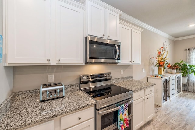 364 Lightning Bug Ln, Freeport, FL 32439 - kitchen with appliances with stainless steel finishes, ornamental molding, light wood-style flooring, white cabinets, and light stone counters
