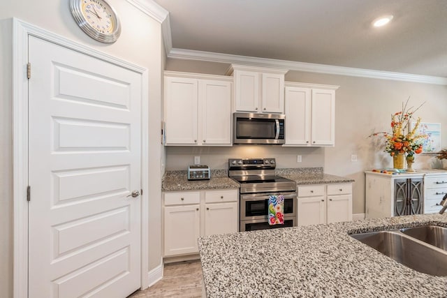 364 Lightning Bug Ln, Freeport, FL 32439 - kitchen featuring appliances with stainless steel finishes, crown molding, white cabinets, light stone counters, and recessed lighting
