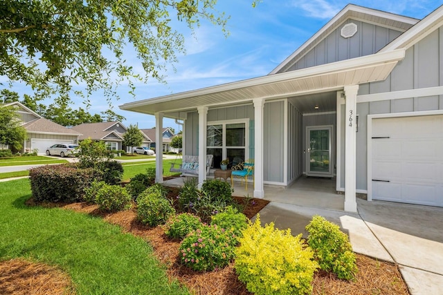 364 Lightning Bug Ln, Freeport, FL 32439 - property entrance featuring board and batten siding, covered porch, a yard, and a garage
