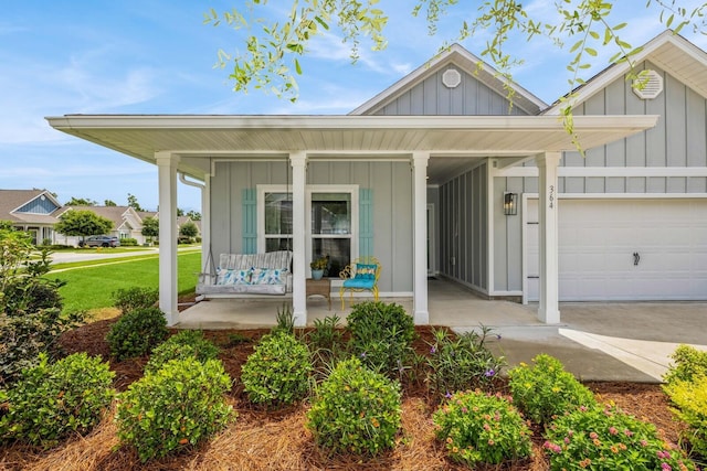 364 Lightning Bug Ln, Freeport, FL 32439 - view of front of home with board and batten siding, covered porch, an attached garage, driveway, and a front yard