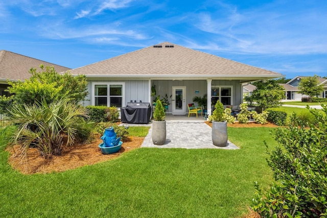 364 Lightning Bug Ln, Freeport, FL 32439 - back of house featuring a patio, a shingled roof, a yard, and board and batten siding