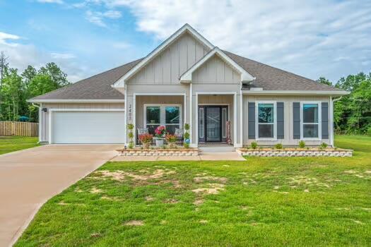 2405 Dakota Way, Crestview, FL 32536 - view of front facade with board and batten siding, a garage, concrete driveway, and a front yard