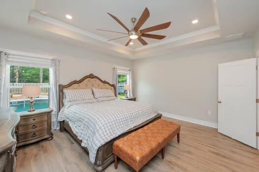 2405 Dakota Way, Crestview, FL 32536 - bedroom with a tray ceiling, multiple windows, light wood-style floors, and recessed lighting