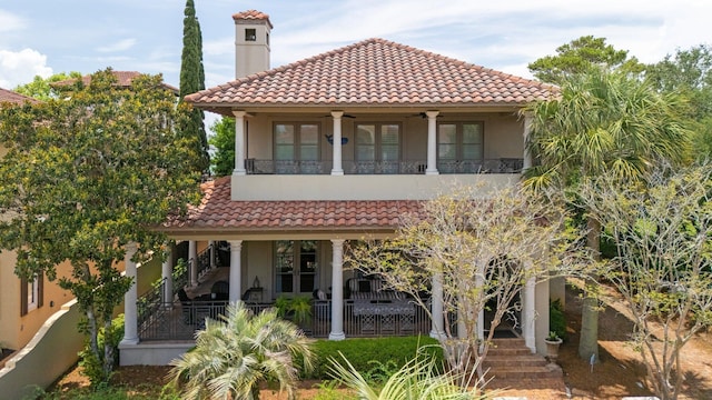 176 Rue Martine, Miramar Beach, FL 32550 - view of front of home with stucco siding, a tile roof, a balcony, ceiling fan, and a chimney