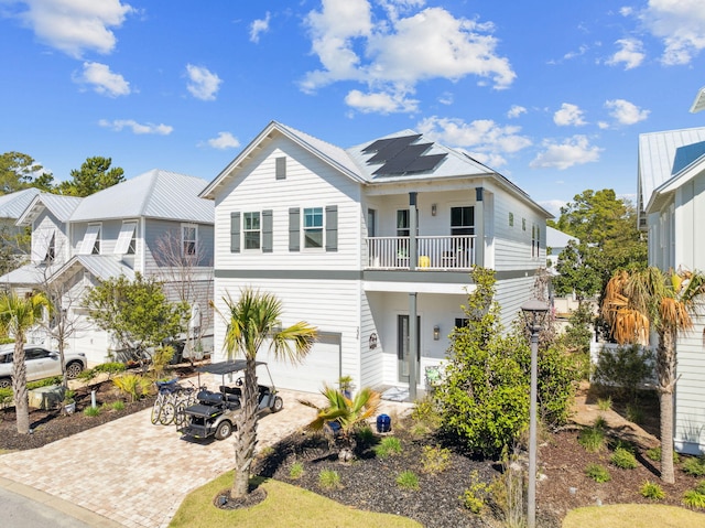 234 Grande Pointe Cir, Inlet Beach, FL 32461 - view of front facade with a balcony, roof mounted solar panels, decorative driveway, and an attached garage