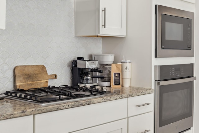 234 Grande Pointe Cir, Inlet Beach, FL 32461 - kitchen featuring appliances with stainless steel finishes, light stone countertops, white cabinets, and wallpapered walls