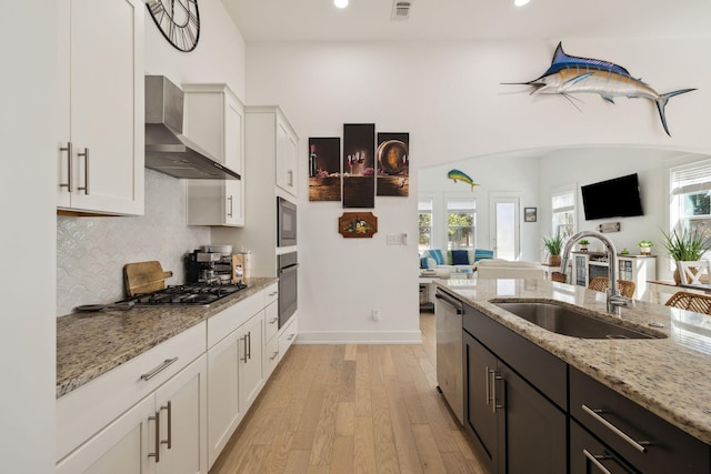 234 Grande Pointe Cir, Inlet Beach, FL 32461 - kitchen with wall chimney exhaust hood, appliances with stainless steel finishes, open floor plan, light wood-type flooring, and white cabinets