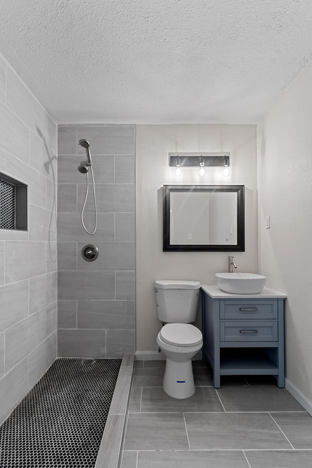 1023 W Webster Dr, Pensacola, FL 32505 - bathroom featuring a tile shower, vanity, and a textured ceiling