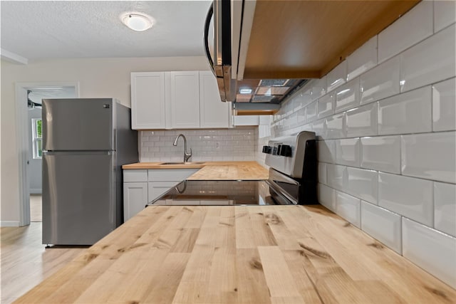 1023 W Webster Dr, Pensacola, FL 32505 - kitchen with wood counters, stainless steel appliances, wood finished floors, tasteful backsplash, and white cabinets