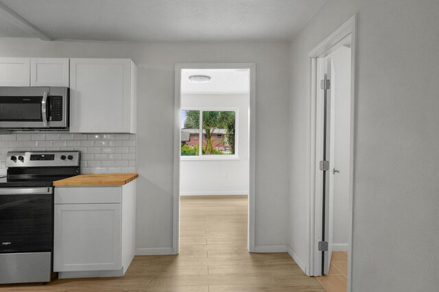 1023 W Webster Dr, Pensacola, FL 32505 - kitchen with appliances with stainless steel finishes, butcher block counters, white cabinets, and light wood-style floors