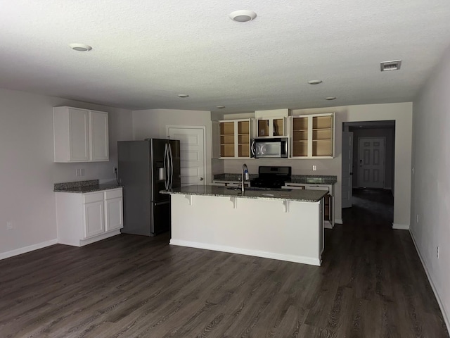 2825 Patriot Ridge Dr, Crestview, FL 32539 - kitchen featuring stainless steel appliances, open shelves, dark stone counters, dark wood-style flooring, and a kitchen breakfast bar