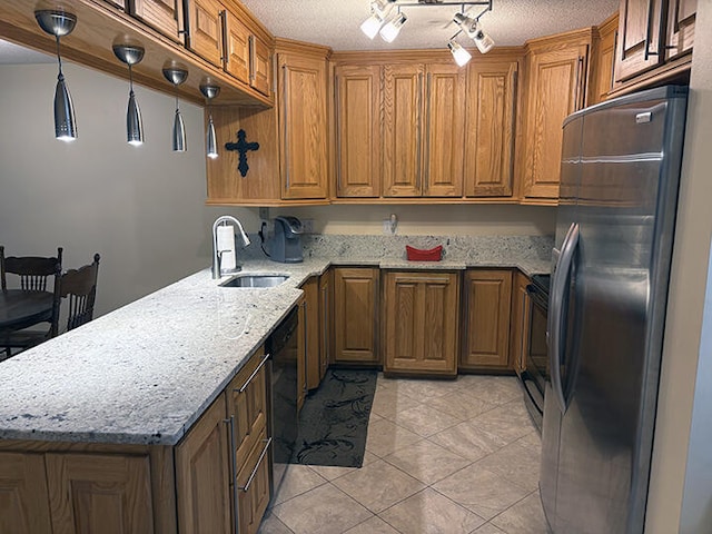 3861 Indian Trl Unit 104, Destin, FL 32541 - kitchen featuring stainless steel fridge, brown cabinetry, a peninsula, stove, and a textured ceiling