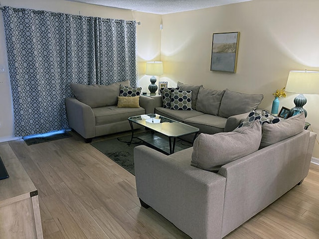3861 Indian Trl Unit 104, Destin, FL 32541 - living area featuring light wood-type flooring and a textured ceiling