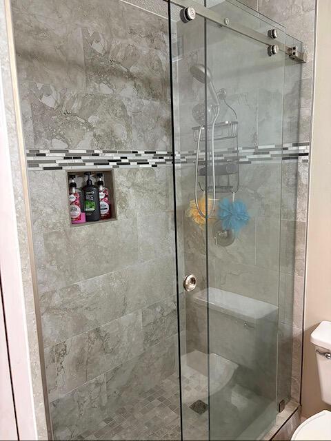 3861 Indian Trl Unit 104, Destin, FL 32541 - full bathroom featuring toilet and a stall shower