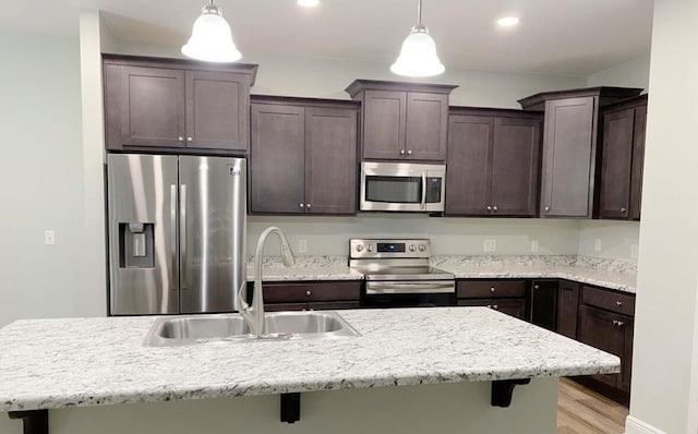 196 Johnson Ct, Crestview, FL 32536 - kitchen with stainless steel appliances, dark brown cabinets, a kitchen breakfast bar, pendant lighting, and recessed lighting