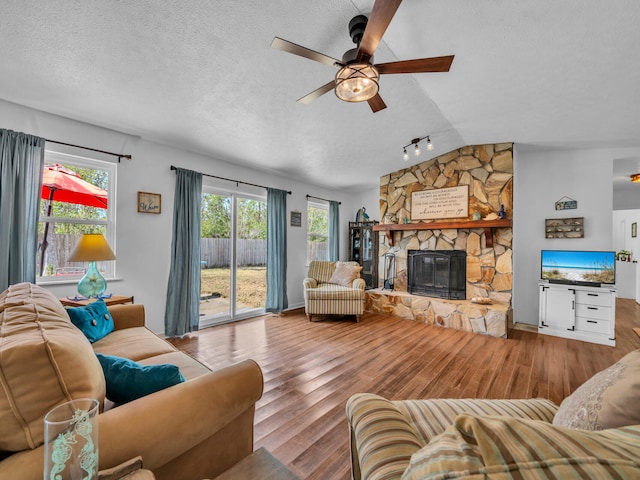 2016 E Three Putt Ln, Panama City, FL 32404 - living area with wood finished floors, ceiling fan, a stone fireplace, lofted ceiling, and a textured ceiling