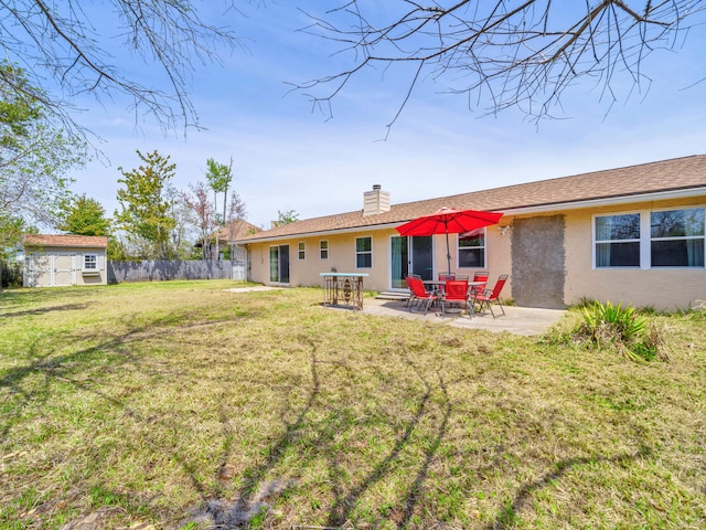 2016 E Three Putt Ln, Panama City, FL 32404 - back of property with a patio, a chimney, stucco siding, and a shed