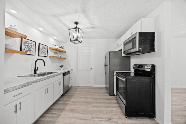 4352 Watkins St, Pace, FL 32571 - kitchen featuring stainless steel appliances, open shelves, white cabinets, light wood finished floors, and a textured ceiling