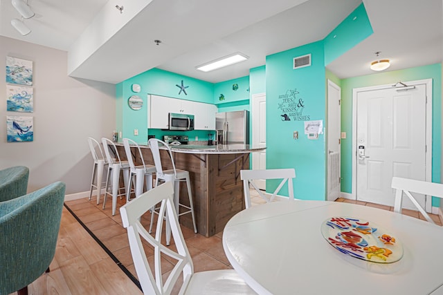 9900 S Thomas Dr Unit 2015, Panama City Beach, FL 32408 - dining area with baseboards and light wood-style flooring