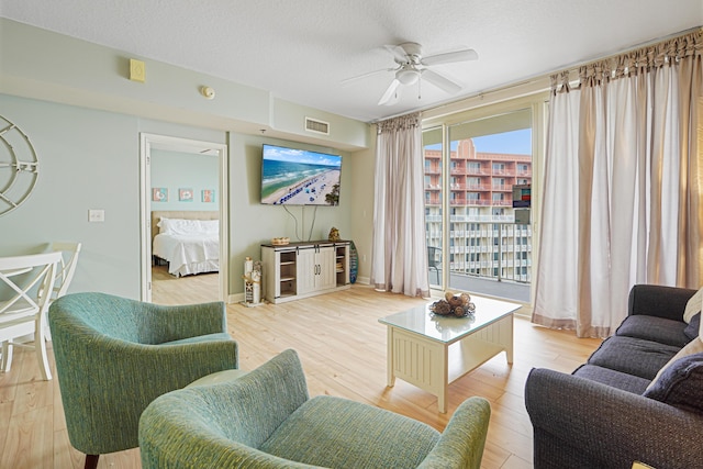 9900 S Thomas Dr Unit 2015, Panama City Beach, FL 32408 - living area featuring a ceiling fan, light wood finished floors, and a textured ceiling
