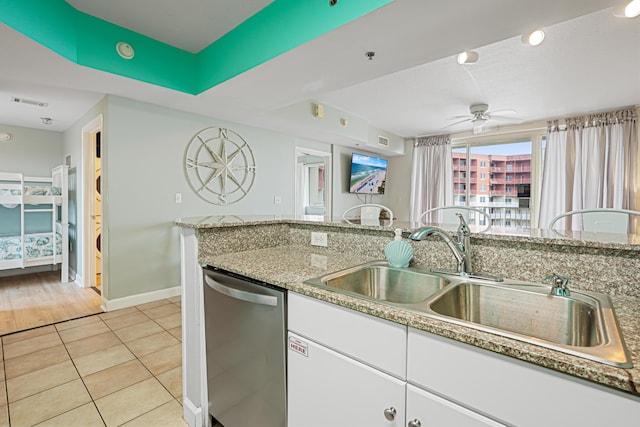 9900 S Thomas Dr Unit 2015, Panama City Beach, FL 32408 - kitchen with stainless steel dishwasher, ceiling fan, white cabinetry, light tile patterned flooring, and light stone counters
