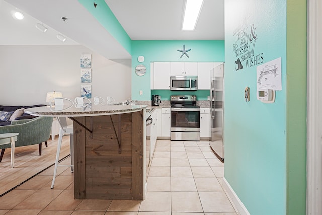 9900 S Thomas Dr Unit 2015, Panama City Beach, FL 32408 - kitchen with appliances with stainless steel finishes, a peninsula, white cabinetry, and open floor plan