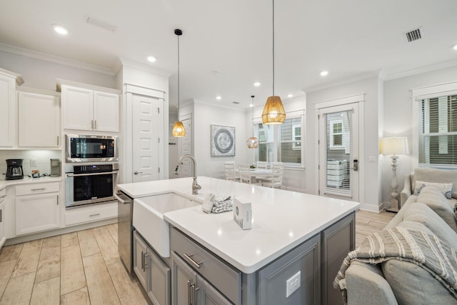 309 Milestone Dr Unit A, Inlet Beach, FL 32461 - kitchen with stainless steel appliances, gray cabinetry, open floor plan, crown molding, and light wood-type flooring