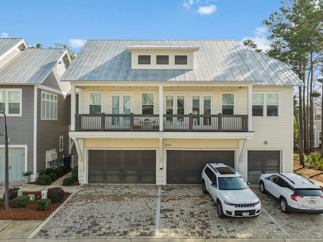 309 Milestone Dr Unit A, Inlet Beach, FL 32461 - view of front of property featuring an attached garage, a balcony, decorative driveway, and a metal roof