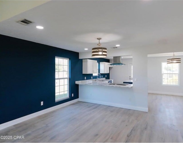 7202 Ranier St, Panama City, FL 32404 - kitchen with wall chimney exhaust hood, a chandelier, light countertops, light wood-style floors, and decorative light fixtures