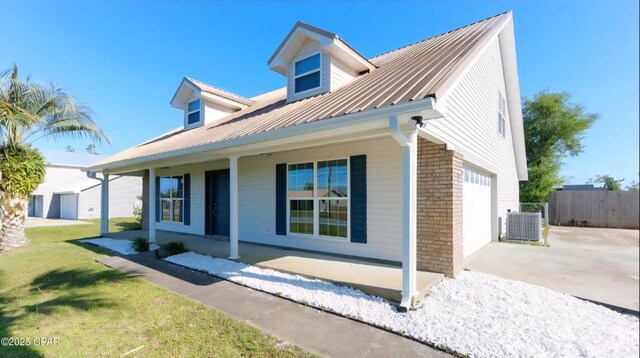 7202 Ranier St, Panama City, FL 32404 - view of home's exterior featuring covered porch, an attached garage, brick siding, concrete driveway, and a metal roof
