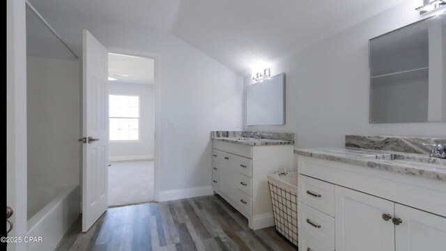 7202 Ranier St, Panama City, FL 32404 - bathroom with wood finished floors, two vanities, and shower / bathtub combination