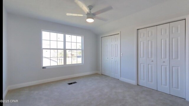 7202 Ranier St, Panama City, FL 32404 - unfurnished bedroom featuring two closets, carpet floors, vaulted ceiling, and ceiling fan