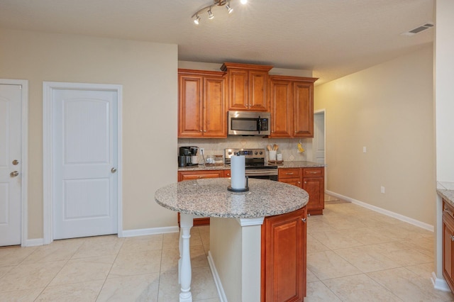 4530 Annabelle Ln, Crestview, FL 32539 - kitchen with stainless steel appliances, light tile patterned floors, tasteful backsplash, and light stone countertops