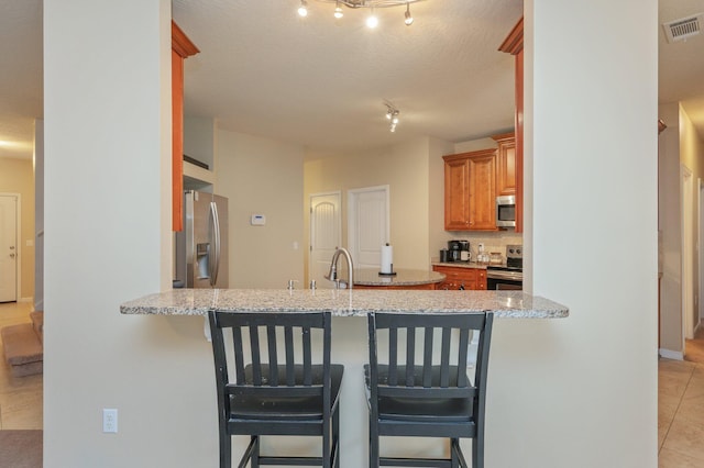4530 Annabelle Ln, Crestview, FL 32539 - kitchen featuring stainless steel appliances, a peninsula, light tile patterned floors, and rail lighting