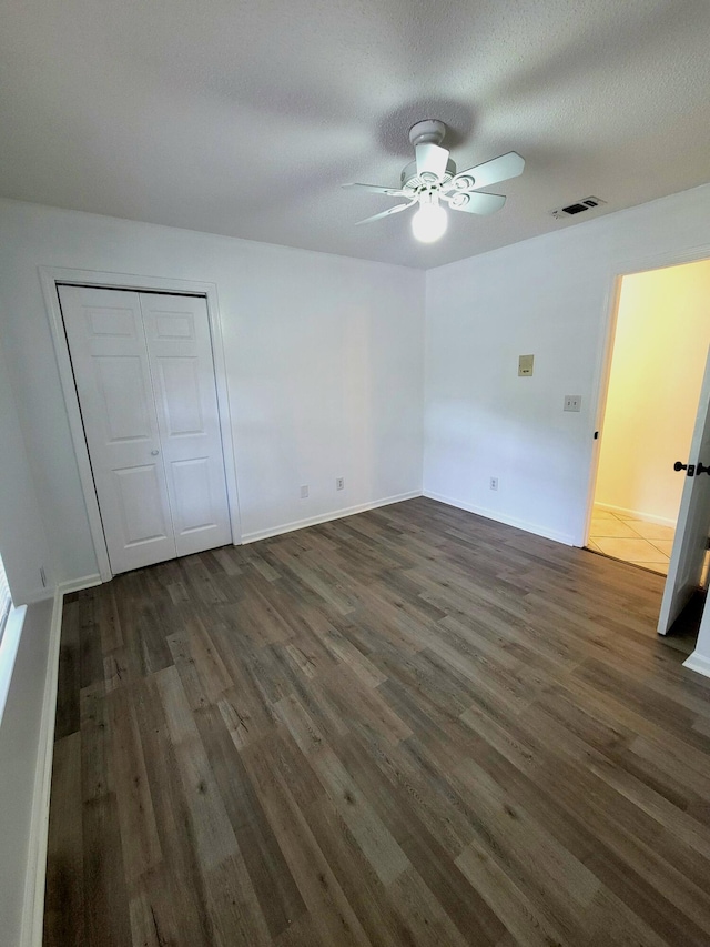 6868 E Bay Blvd, Navarre, FL 32566 - unfurnished bedroom with dark wood-style flooring, a closet, and ceiling fan
