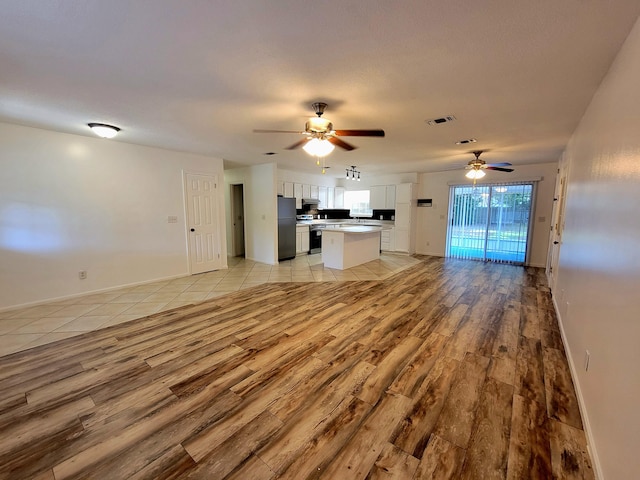 6868 E Bay Blvd, Navarre, FL 32566 - unfurnished living room featuring light wood-type flooring and a ceiling fan