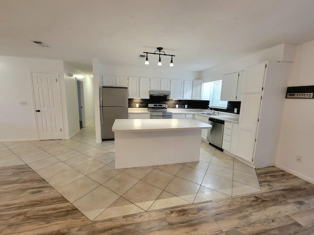6868 E Bay Blvd, Navarre, FL 32566 - kitchen featuring appliances with stainless steel finishes, a center island, light countertops, and white cabinetry