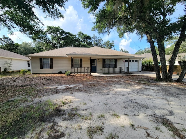 6868 E Bay Blvd, Navarre, FL 32566 - ranch-style home featuring covered porch, a garage, and asphalt driveway