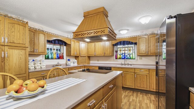 4936 Grassy Pond Rd, Chipley, FL 32428 - kitchen with freestanding refrigerator, island range hood, light wood-style flooring, a textured ceiling, and black electric stovetop