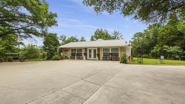 4936 Grassy Pond Rd, Chipley, FL 32428 - view of front of property with french doors, a front yard, stone siding, and a metal roof