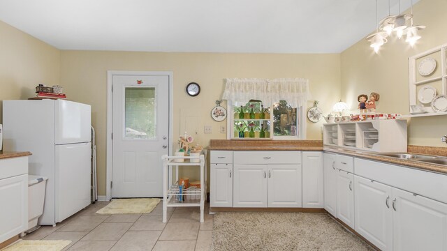 4936 Grassy Pond Rd, Chipley, FL 32428 - kitchen featuring freestanding refrigerator, light tile patterned floors, and white cabinetry