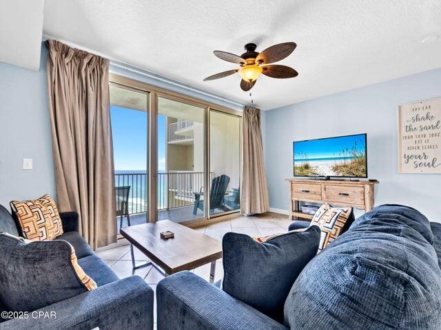 9900 S Thomas Dr Unit 1604, Panama City Beach, FL 32408 - living room featuring a ceiling fan, tile patterned flooring, and a textured ceiling