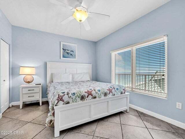 9900 S Thomas Dr Unit 1604, Panama City Beach, FL 32408 - bedroom with light tile patterned floors and ceiling fan