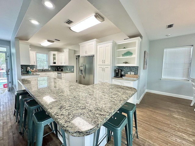 83 Sunfish St, Destin, FL 32541 - kitchen featuring stainless steel appliances, open shelves, decorative backsplash, white cabinetry, and dark wood-style floors