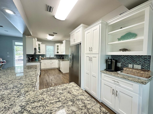 83 Sunfish St, Destin, FL 32541 - kitchen featuring appliances with stainless steel finishes, stone countertops, decorative backsplash, white cabinets, and glass insert cabinets