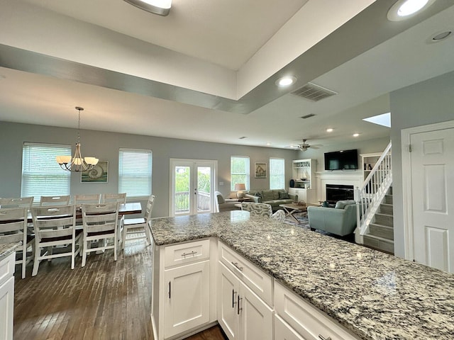 83 Sunfish St, Destin, FL 32541 - kitchen with light stone counters, dark wood-style floors, white cabinets, hanging light fixtures, and a ceiling fan