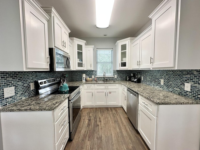 83 Sunfish St, Destin, FL 32541 - kitchen featuring appliances with stainless steel finishes, white cabinets, wood finished floors, and glass insert cabinets
